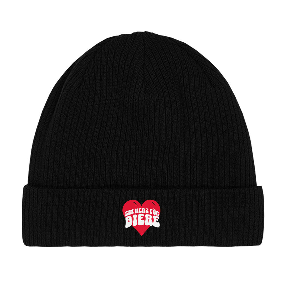 Schwarzer Beanie mit einem roten Herz in der Mitte. Darauf steht in verspielten, weißen Buchstaben „EIN HERZ FÜR BIERE“. Das Design ist humorvoll und spielt auf die bekannte Redewendung „Ein Herz für …“ an, kombiniert mit einer Liebe zu Bier.