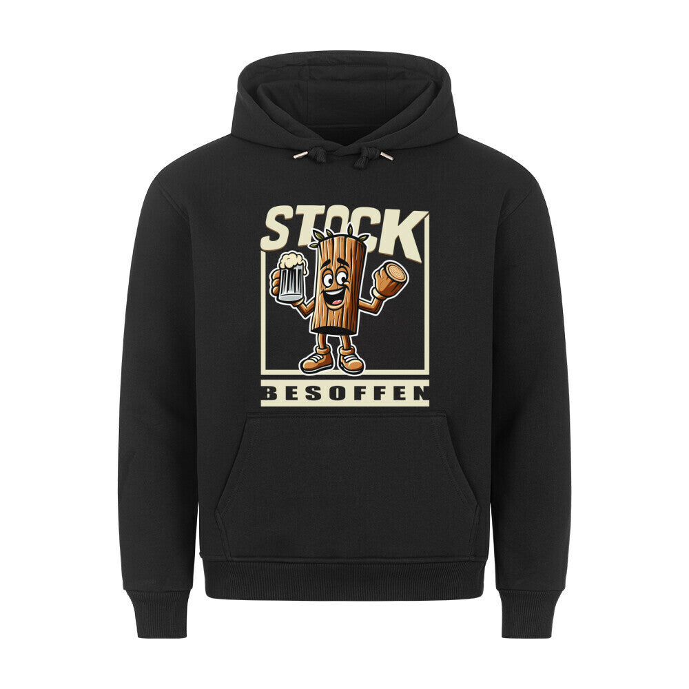 Schwarzer Hoodie mit einem humorvollen Design. In der Mitte ist eine cartoonartige Holzfigur mit Armen, Beinen und einem fröhlichen Gesicht zu sehen. Sie hält ein Bierglas in der einen Hand und ein abgesägtes Stück Holz in der anderen. Darüber steht in großen, beigen Buchstaben „STOCK“, darunter „BESOFFEN“. Das Wortspiel kombiniert „Stock“ (Holzstück) mit „stark besoffen“ und sorgt für einen witzigen Effekt.