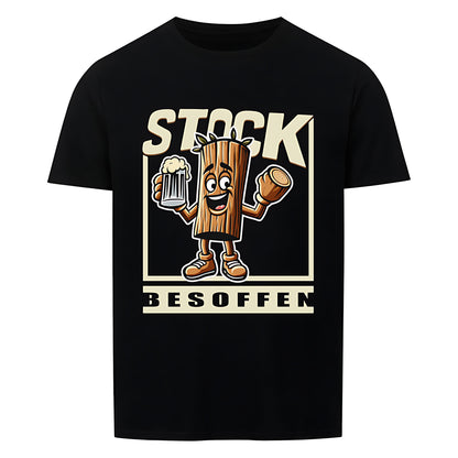 Schwarzes T-Shirt mit einem humorvollen Design. In der Mitte ist eine cartoonartige Holzfigur mit Armen, Beinen und einem fröhlichen Gesicht zu sehen. Sie hält ein Bierglas in der einen Hand und ein abgesägtes Stück Holz in der anderen. Darüber steht in großen, beigen Buchstaben „STOCK“, darunter „BESOFFEN“. Das Wortspiel kombiniert „Stock“ (Holzstück) mit „stark besoffen“ und sorgt für einen witzigen Effekt.